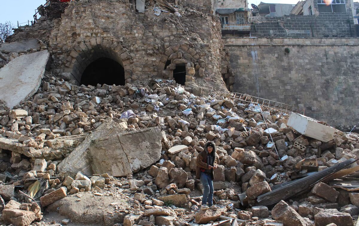 صبي يقف فوق الركام بالقرب من قلعة حلب التاريخية بعد تعرضها للزلزال – تاريخ الصورة: 7 شباط 2023