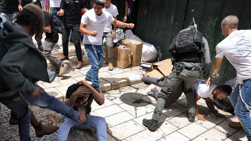 مستوطنان يعتدون على فلسطنيين بالقرب من باب العامود في البلدة القديمة بالقدس الشرقية المحتلة، 18 أيار/مايو 2023 (AFP)