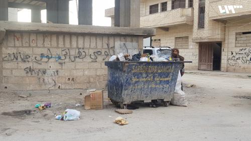 نبش القمامة من حاوية في مدينة القامشلي