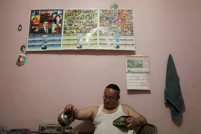 زبولون سيمانتوف، آخر يهودي معروف يعيش في أفغانستان ، يصب لنفسه كوباً من الشاي، خلال عشاء السبت في منزله في كابول.