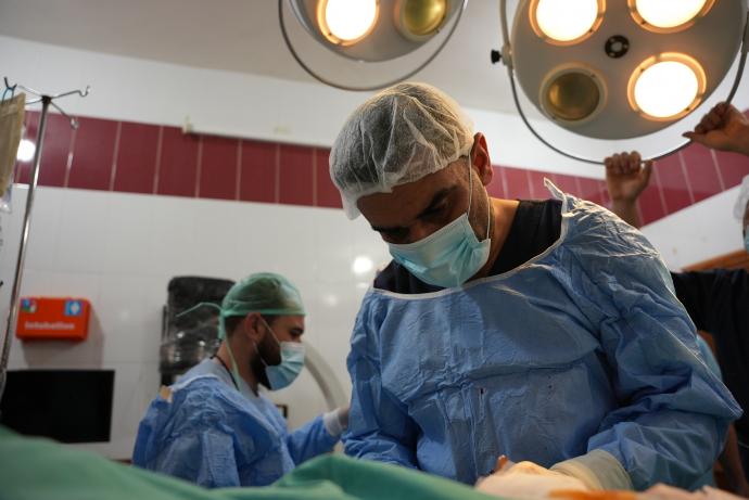 الطبيب عبد السلام النعسان خلال إجراء العمليات الجراحية للمصابين في الزلزال (تلفزيون سوريا)