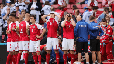 لاعبو الدانمارك يشكلون حلقة حول زميلهم بينما يتوجه المسعفون إلى كريستيان إريكسن بعد سقوطه على أرضية الملعب.