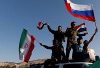 جنود سوريون يحملون العلمين الروسي والإيراني إلى جانب السوري - المصدر: الإنترنت