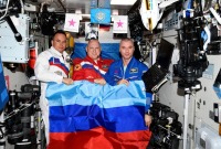 رواد الفضاء الروس أوليغ آرتيمييف ودينيس ماتفييف وسيرغي كورساكوف وهم يحملون علم دولة لوهانسك في محطة الفضاء الدولية بتاريخ 4 تموز 2022 