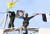 عنصران من "قسد" وقوات النظام في إحدى النقاط العسكرية بعين العرب (كوباني) – Getty