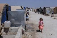 طفلة بالقرب من خزان مياه في إحدى المخيمات السورية شمال سوريا (الأناضول)