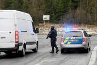 عنصر من الشرطة التشيكية يوقف إحدى السيارات المشتبه بها (رويترز)
