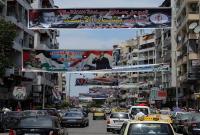 صور ولافتات مؤيدة لبشار الأسد في أحد شوارع اللاذقية (Getty)
