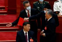 لحظة إخراج الرئيس الصيني السابق من مؤتمر الحزب الشيوعي في بكين (رويترز)