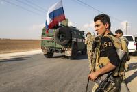عناصر من قسد أمام دورية روسية (AFP)
