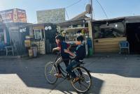طفلان سوريان يركبان دراجة في الشارع الرئيسي بمخيم الزعتري في الأردن
