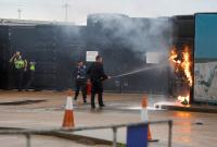 عناصر من الجيش وحرس الحدود البريطانية يطفئون حريقاً في مركز دوفر بعد الهجوم عليه بقنبلة حارقة (رويترز)