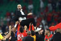 مدرب المغرب وليد الركراكي يحتفل مع اللاعبين بعد التأهل إلى نصف النهائي كأس العالم - 10 كانون الأول (رويتر)