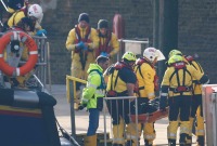 طواقم الإنقاذ يحملون جثث طالبي لجوء على نقالة بعد عودتهم إلى ميناء دوفر البريطاني - 14 كانون الأول (رويترز)