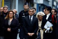 وزير الداخلية الفرنسي جيرالد دارمانان في زيارة إلى موقع إطلاق النار في باريس، الجمعة 23 كانون أول 2022 (رويترز)