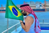اللاجئ السوري عبد الباسط جارور وهو يقبل علم البرازيل