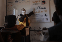 متطوعة من "الخوذ البيضاء" تشرح لتلاميذ في الفصل أعراض الكوليرا وطرق الوقاية منها (الدفاع المدني السوري)