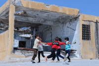 أطفال يلعبون أمام مدرسة مدمرة في إدلب - إنقاذ الطفولة