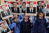 أطفال سوريون يحملون صور بشار الأسد خلال مسيرة لدعم النظام في مدينة حلب - 17 تشرين الثاني 2014 (AFP)