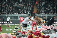 جماهير تلقي ألعاباً على أرضية الملعب ولاعبين وعمّال يجمعون الهدايا في إسطنبول (رويترز)