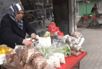 امرأة سورية تبيع على بسطة لتأمين لقمة العيش 