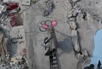الفنانة السورية سلام حامد ترسم جدارية على منزل دمره الزلزال في جنديريس ـ رويترز
