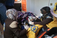 متطوعتان في الدفاع المدني السوري خلال إنقاذهن ناجية من الزلزال في شمال غربي سوريا (الدفاع المدني/ فيس بوك)