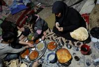 أم تفطر مع أطفالها في خيمة بمدينة جنديرس شمالي سوريا ـ رويترز 