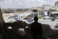 A member of the regime forces watches passers-by from inside a destroyed building in Daraa al-Balad (archive/AFP)