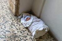 طفل رضيع مرمي على مدخل بناء في مدينة حماة (فيسبوك)