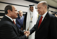 الرئيس التركي رجب طيب أردوغان يصافح نظيره المصري عبد الفتاح السيسي خلال افتتاح نهائيات كأس العالم لكرة القدم في قطر (الأناضول)