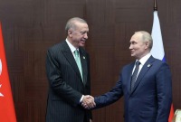 الرئيس التركي رجب طيب أردوغان يصافح الرئيس الروسي فلاديمير بوتين