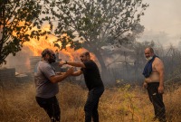 متطوعون يحاولون إطفاء حريق غابات مشتعل في قرية هاسيا بالقرب من أثينا - 22 آب 2023 (رويترز)