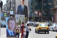ملصقات لصور رئيس النظام السوري بشار الأسد تملأ شوارع وساحات دمشق (رويترز)