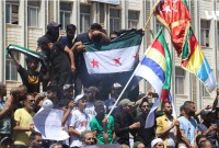 متظاهرون يرفعون علم الثورة في ساحة الكرامة بمدينة السويداء - تلفزيون سوريا