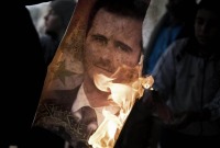 إشعال النار في صورة كبيرة لبشار الأسد كانت منصوبة في ساحة تشرين وسط السويداء - AFP