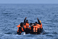 أشخاص في قارب مطاطي يسافرون عبر القناة الإنجليزية ، متجهين إلى دوفر على الساحل الجنوبي لإنجلترا ، 4 مايو 2023 (AFP)