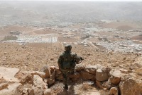 جندي لبناني في موقع للجيش في التلال المطلّة على بلدة عرسال اللبنانية قرب الحدود مع سوريا- رويترز