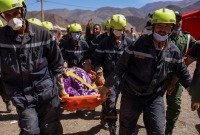 عمال الإنقاذ يحملون جثة أحد ضحايا الزلزال المميت في طلعة نيعقوب بالمغر