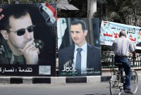 لافتات انتخابية مؤيدة لرئيس النظام السوري بشار الأسد في شوارع دمشق (Getty)