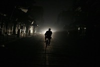 رجل يقود دراجته في إحدى ضواحي العاصمة دمشق خلال انقطاع التيار الكهربائي - AFP