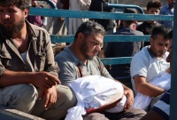 رجل يحمل جثمان طفله بعد مقتله بقصف للنظام السوري على قرية القرقور بريف حماة - الدفاع المدني