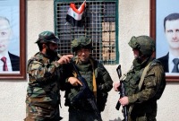 جنديان روسيان إلى جانب عنصر من قوات النظام عند نقطة تفتيش قرب دمشق - 2 آذار 2018 (رويترز)