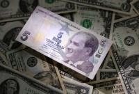 أوراق النقدية بالليرة التركية والدولار الأمريكي (رويترز)