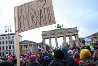 شخص يحمل لافتة كتب عليها "من أجل الديمقراطية" خلال مظاهرة مناهضة لليمين المتطرف في برلين – 14 كانون الثاني 2024 (رويترز)
