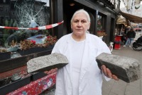 صاحبة المطعم تحمل الأحجار التي رماها السوري على متجرها 