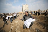 فلسطينيون يحملون أكياس طحين انتزعوها من مساعدات وزّعت قرب نقطة تفتيش إسرائيلية ـ رويترز