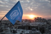 ناشطون ينكّسون علم الأمم المتحدة فوق مبانٍ منهارة جراء الزلزال في سوريا (مواقع التواصل)