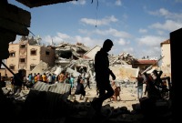 فلسطينيون يتفقدون منزلا تعرض للقصف الإسرائيلي في رفح ـ رويترز