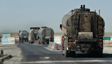 قافلة من شاحنات النفط تمر بنقطة تفتيش تابعة ل"قسد" في محافظة الحسكة - 4 من نيسان 2018 (AP)